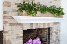 a very easy and chic summer mantel and fireplace decor with a long planter with greenery and hot pink peonies in a basket is wow