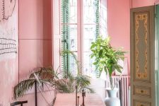 a whimsical pink eat-kitchen with a big dining zone, a pink table, chairs and even shutters on the window looks pop-art and very tropical