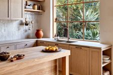 a beautiful Mediterranean kitchen with light stained cabinets, stone countertops, a kitchen island and open shelves