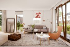 a beautiful mid-century modern living room with a grey sofa and a large rug, a greige egg-shaped chair, a duo of coffee tables, elegant copper lamps