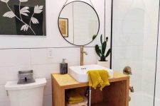 a bold mid-century modern bathroom with black and white penny tiles on the floor, a floating vanity, a round mirror and yellow touches