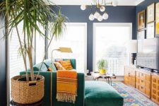 a bold mid-century modern living room with colorful printed rugs, an emerald sectional, printed pillows, stained storage unit and a colorful gallery wlal