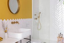 a colorful mid-century modern bathroom with mustard walls, a mosaic tile floor, a white tile shower space and mustard towels
