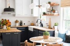 a cool mid-century modern kitchen with graphite grey and white kitchen with butcherblock countertops, a round table and wooden chairs, wooden open shelves