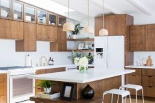 a dark stained mid-century modern kitchen with white countertops, white stools, pendant lamps, gold fixtures is a lovely space