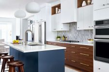 a fabulous mid-century modern kitchen with two tone cabinets, white countertops, a mosaic tile backsplash and a navy kitchen island