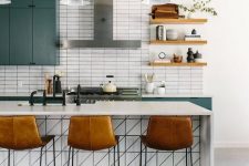 a fantastic mid-century modern kitchen with green cabinets, a white kitchen island, open shelves and leather stools