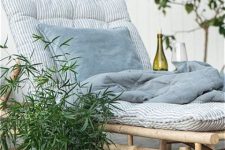 a lovely lounger of bamboo with printed blue bedding and a mattress, potted greenery is a very cool idea for an outdoor space