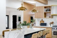 a lovely mid-century modern kitchen with light-stained cabinets, a white chevron backsplash, a navy kitchen island with a white marble countertop