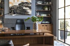 a luxurious mid-century modern home office with grey walls, a glazed wall, a stained desk, built-in storage units and shelves and leather furniture