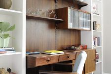a mid-century modern working nook with a stained desk and shelves, a cool chair and a large open storage unit around