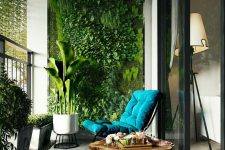 a modern and inviting balcony with a living wall, potted greenery, a wood slice coffee table and a teal lounger is a lovely space to be