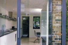 a navy glass sliding door allows to open the kitchen to the terrace any time and lets much natural light in and provides cool views