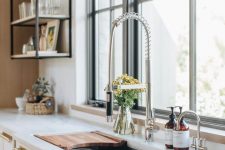 a neutral modern kitchen with gold handles and a chromatic faucet is a very chic idea and the kitchen looks statement and chic