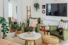 a pretty mid-century modern living room with grene chairs, a blush loveseat, a round table and woven poufs, potted plants and lights