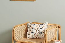 a rattan and cane chair with a printed boho pillow is a gorgeous modern accent piece for any room, it cna fit a modern or a boho interior