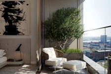 a small and cool balcony with some potted plants, a woven chair with a footrest and a gorgeous view of the city is an ultimate idea