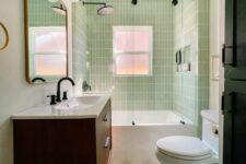a small and cool mid-century modern bathroom with skinny green tiles, a printed tile floor, a stained vanity, white appliances