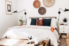 a small yet welcoming mid-century modern bedroom with a wooden bed, an upholstered bench, decorative baskets, printed pillows and an artwork