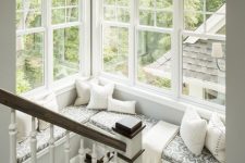 a staircase with cozy nook created around a large corner window, with printed upholstery and neutral pillows is amazing