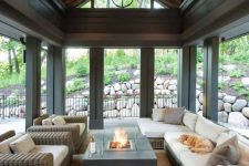 a stylish modern farmhouse screened porch with woven furniture, a portable fire pit, some lights is a lovely space to spend time