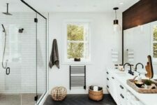 an airy mid-century modern bathroom with white tiles, a skylight, a boho rug, a large vanity with a wooden top and a large shower space with windows