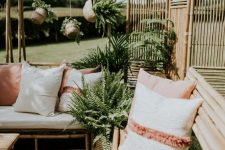 cool and simple bamboo furniture with muted and neutral pillows, a bamboo screen and potted plants for a lovely and welcoming outdoor space