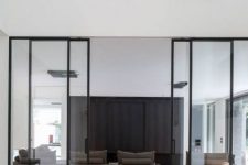 modern glass and black framing sliding doors delicately separate the spaces and let light in and out