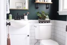 07 a black and white powder room with black walls, white subway tiles, Moroccan tiles on the floor, a white vanity and white appliances