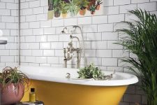 12 a pretty bathroom with white subway tiles, black and white Moroccan ones on the floor, a mustard vintage tub, potted plants is a chic idea