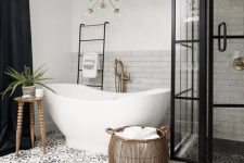 20 a stylish bathroom with marble and Moroccan tiles, a vintage tub, a shower space with framed glass walls, a gilded chandelier and a basket