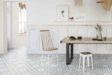 29 a laid-back dining room with white panels on the walls, a Moroccan tile floor, a dining table, cool chairs and woven pendant lamps