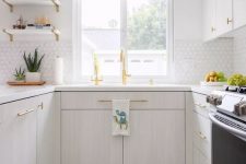 31 a serene kitchen with whitewashed cabinets, white tiles on the backsplash, colorful Moroccan tiles and gold fixtures