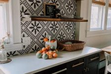 a black farmhouse kitchen with white stone countertops, black and white Moroccan tiles and open shelves is a very chic idea
