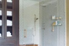 a chic bathroom with blue arabesque tiles in the shower, a stained bench and a dark stained storage unit is a very elegant and cool space