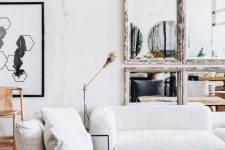 a chic living room with low seating furniture, a double wooden coffee table, a catchy mirror wall with shabby chic frames
