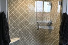 a chic shower space with grey arabesque tiles with white grout to make them stand out and grey marble tiles on the floor looks very eye-catchy
