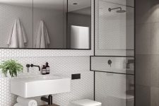 a contemporary bathroom clad with hex tiles, grey large scale ones, a shower space, a large mirror and a floating sink and shelf