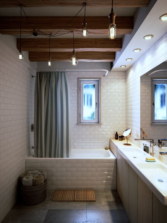 a contemporary bathroom clad with white subway tiles, with wooden beams and hanging bulbs, a built-in sleek vanity with two sinks