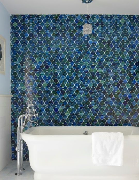 a contemporary bathroom with a fantastic blue and green arabesque tile accent wall plus a white chic bathtub is amazing