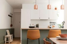 a contemporary kitchen with sleek white cabinets, a green kitchen island, amber leather stools and copper pendant lamps