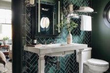 a dark and chic bathroom clad with geo and chevron tiles, a console sink, a mirror, sconces and white appliances is cool