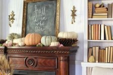 a fall woodland mantel with oversized pinecones and pumpkins, branches and a chalkboard sign is a lovely and pretty idea