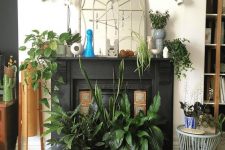 a fireplace with a black mantel, lots of potted plants on display in the fireplace and on the mantel is a gorgeous idea