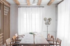 a lovely Japandi dining room with wooden beams, a storage unit clad with wooden slabs, a wooden dining table and black chairs