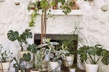 a lovely space with a white stone accent wall and a built-in fireplace used as a potted plant display and all around it too