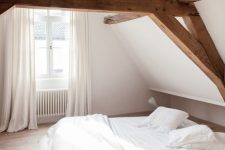 a minimal bedroom with rich-stained wooden beams, a stained low bed and neutral textiles is a very fresh idea