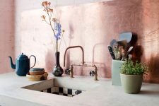 a minimalist dark green kitchen with a thick concrete countertop and a copper backsplash is a lovely and bold idea to rock