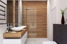 a modern bathroom clad with wood look and neutral tiles, with a long double vanity, white appliances and built-in lights