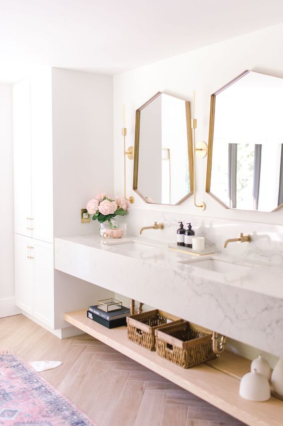 a neutral and chic bathroom with a built in wardrobe, a built in vanity and sink slab, a floating shelf and geometric mirrors is a very lovely space
